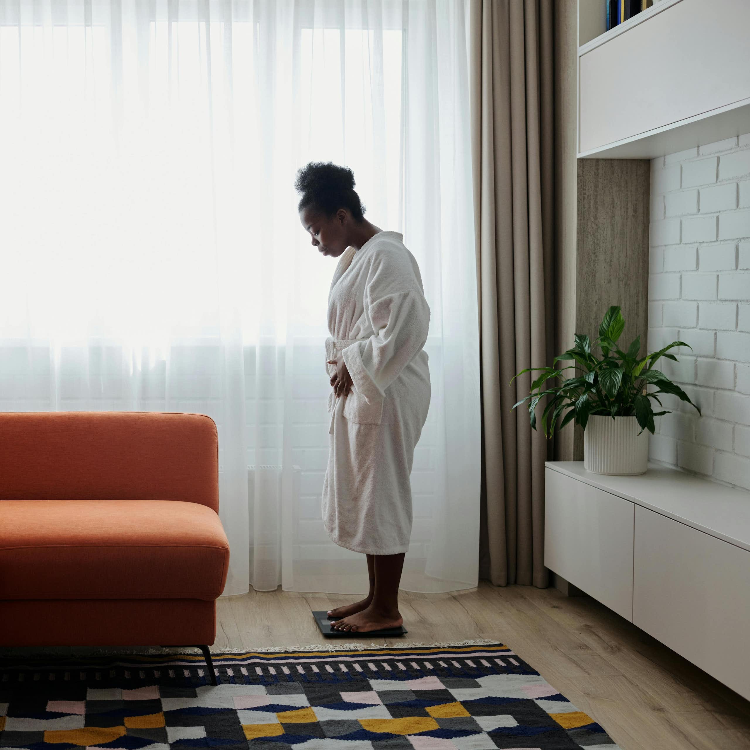 Woman weighs herself in living room
