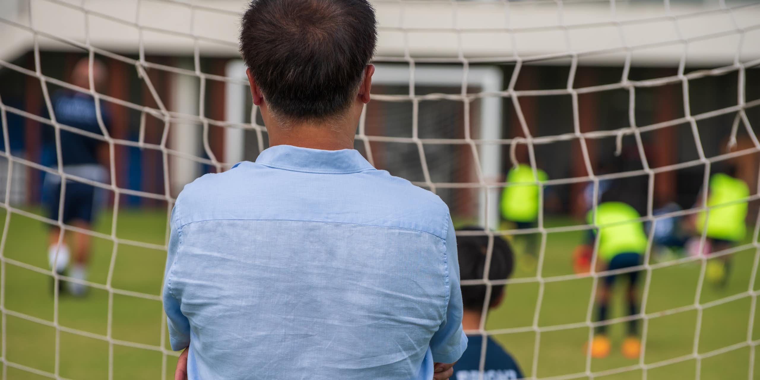 A man watches junior soccer