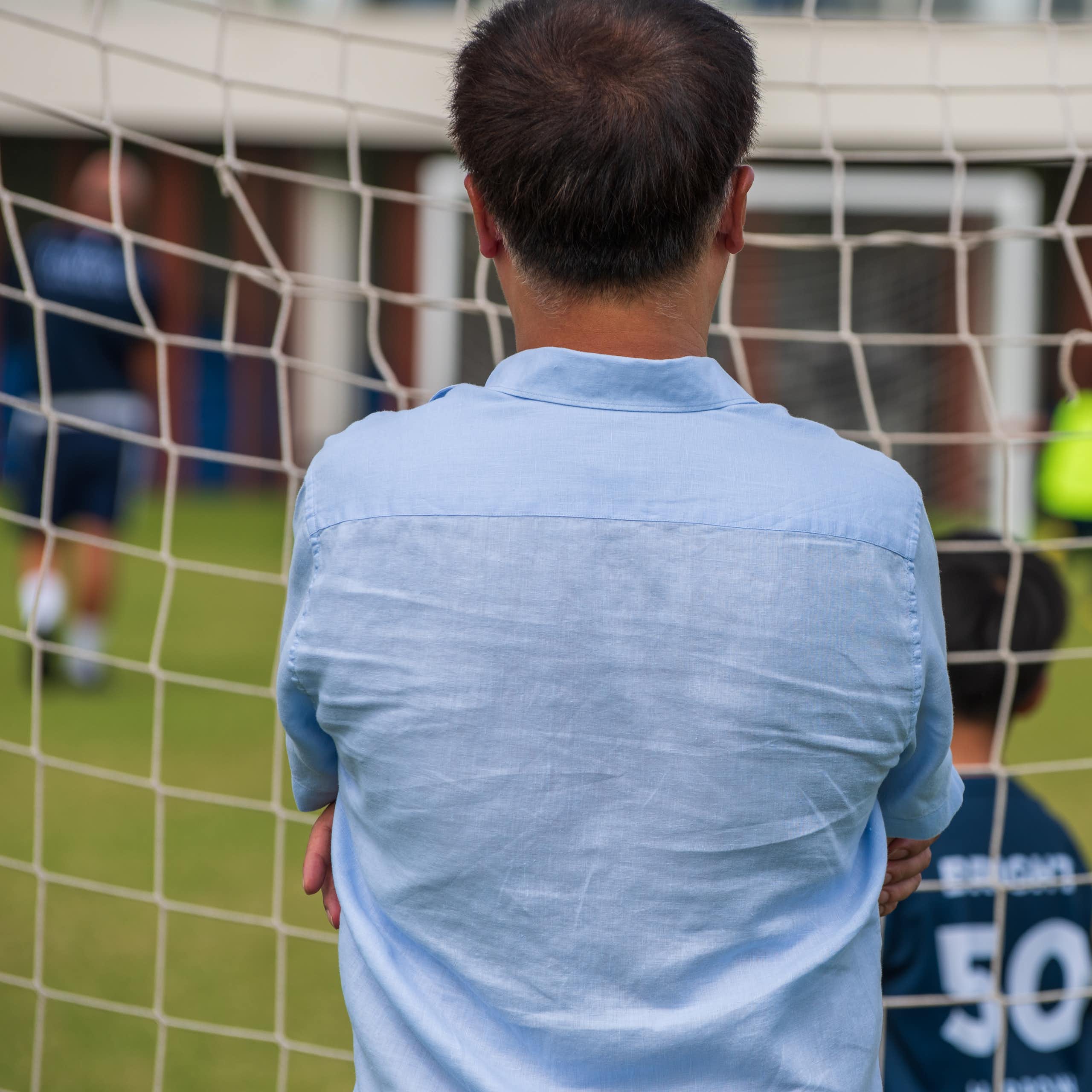 A man watches junior soccer