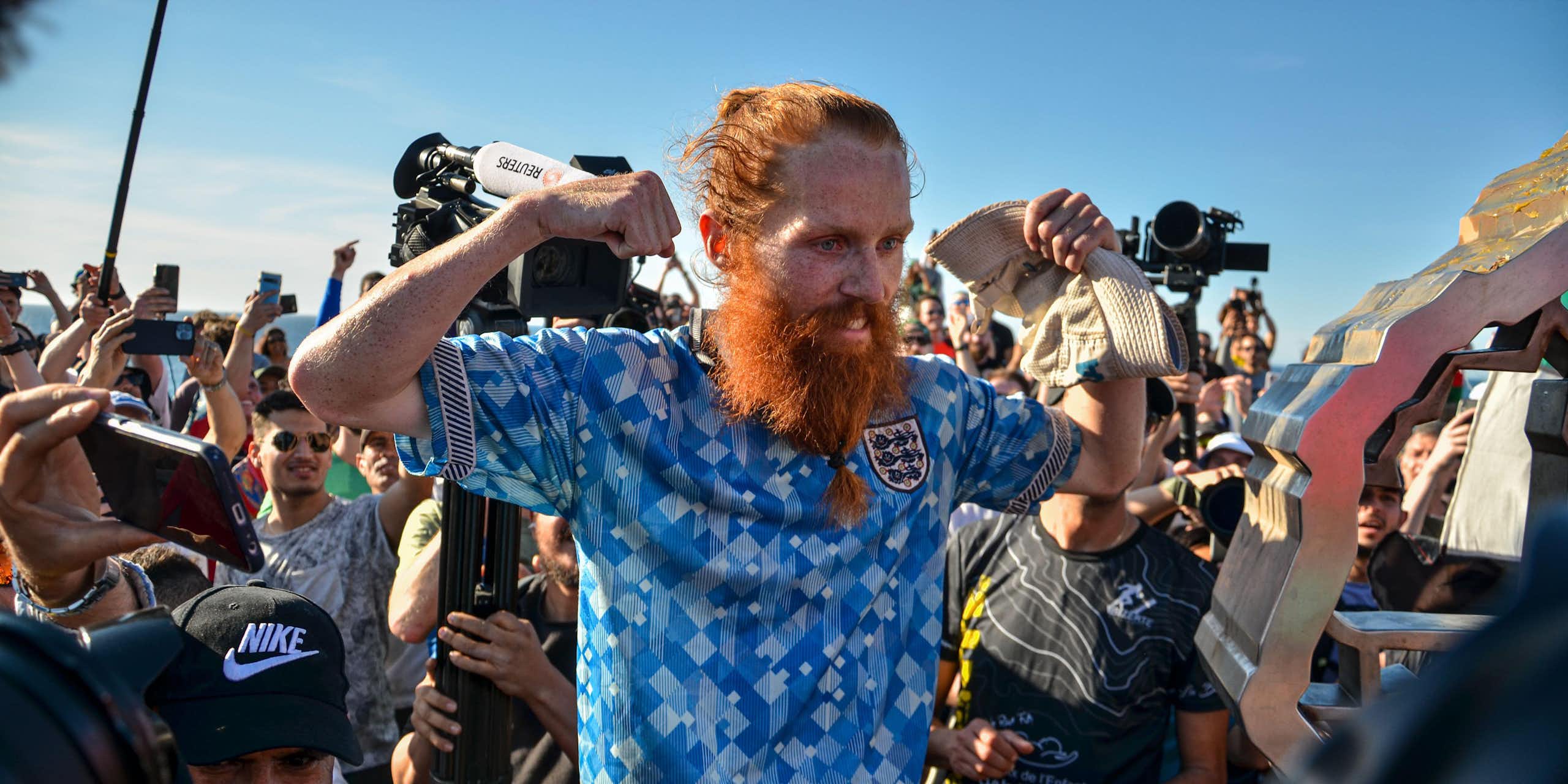 A photo of Russ Cook flexing his muscles for photographers.