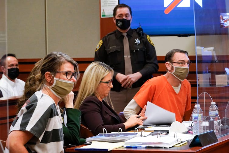 James and Jennifer Crumbley, far left and right, during their trial, sitting in a courtroom.