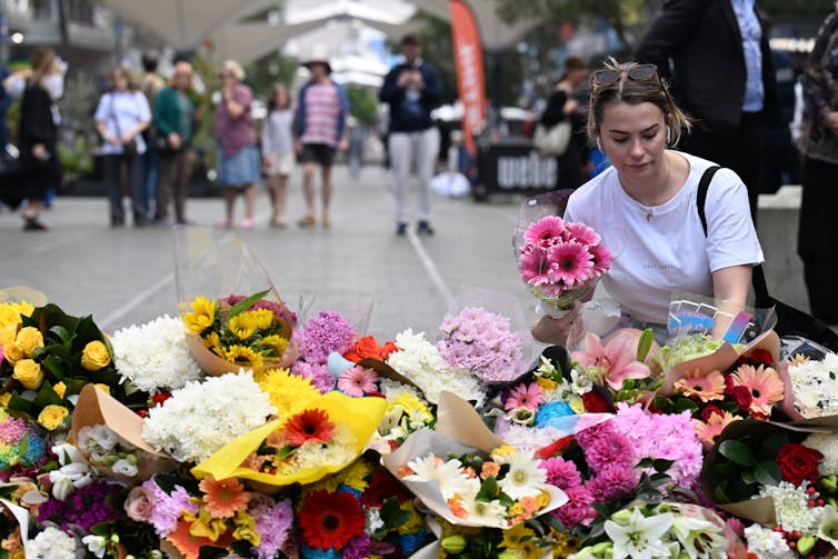 Woman places flowers at the site of the attack