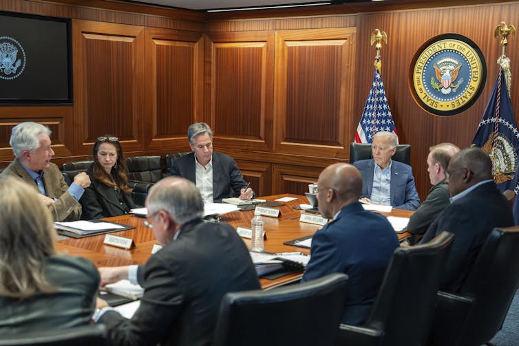 Men and women sit around a table in a room.