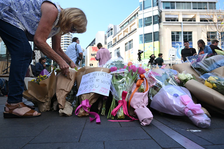 A mourner lays flowers at the scene of the mass stabbing at Bondi