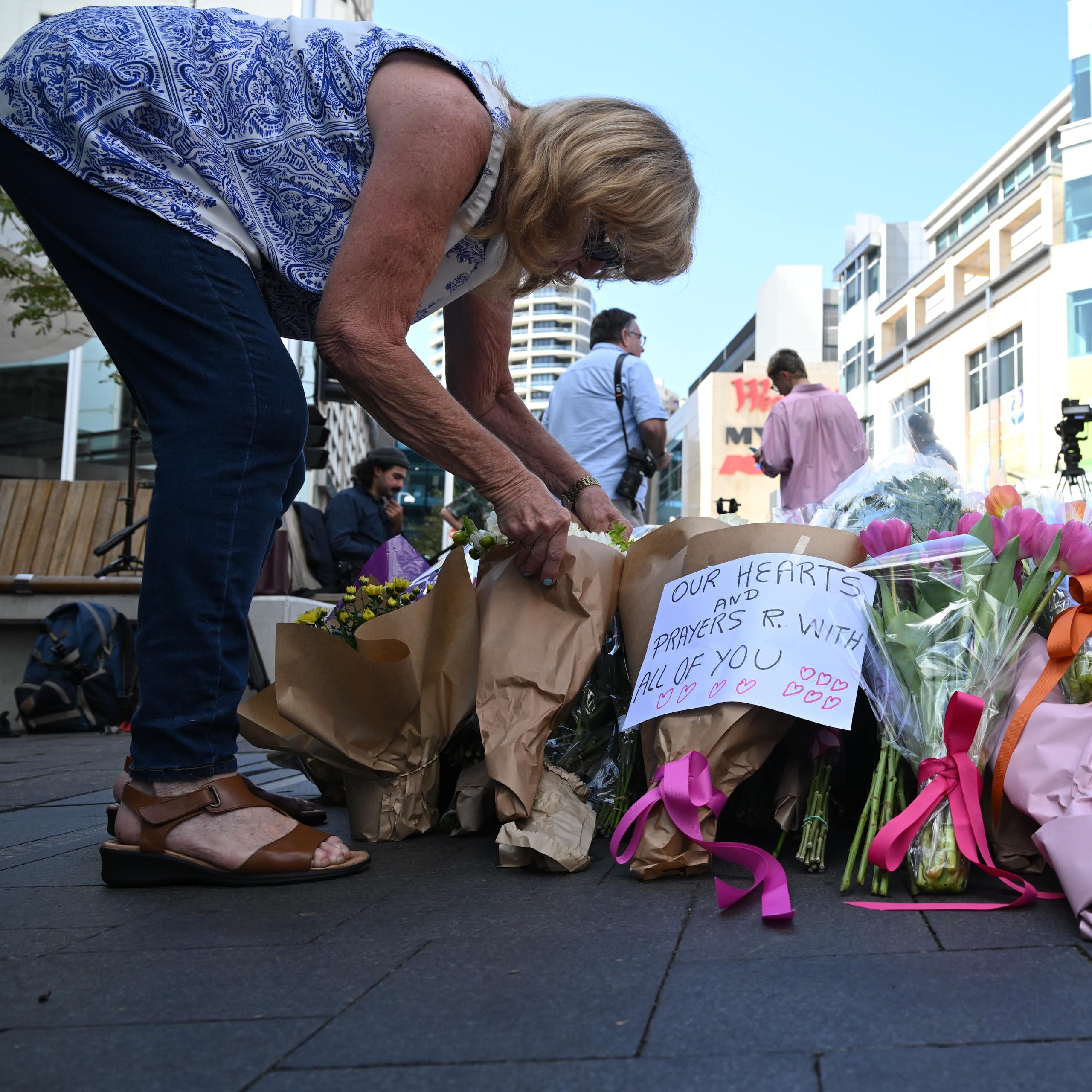 A mourner lays flowers at the scene of the mass stabbing at Bondi