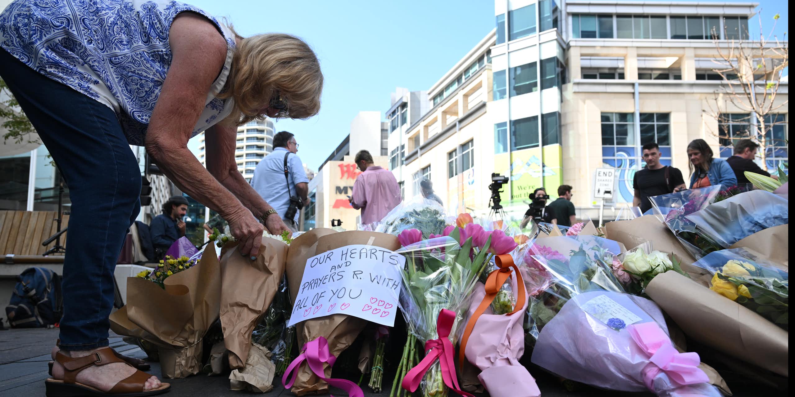 A mourner lays flowers at the scene of the mass stabbing at Bondi