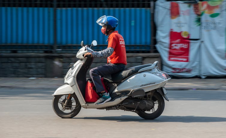 Zomato delivery driver rides a motorbike