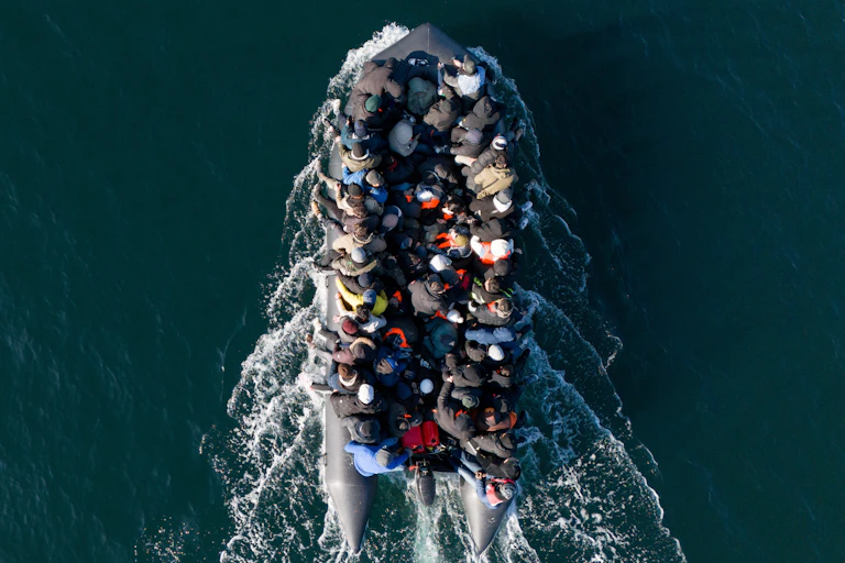 View from directly above of a small boat filled with people, surrounded by deep blue water