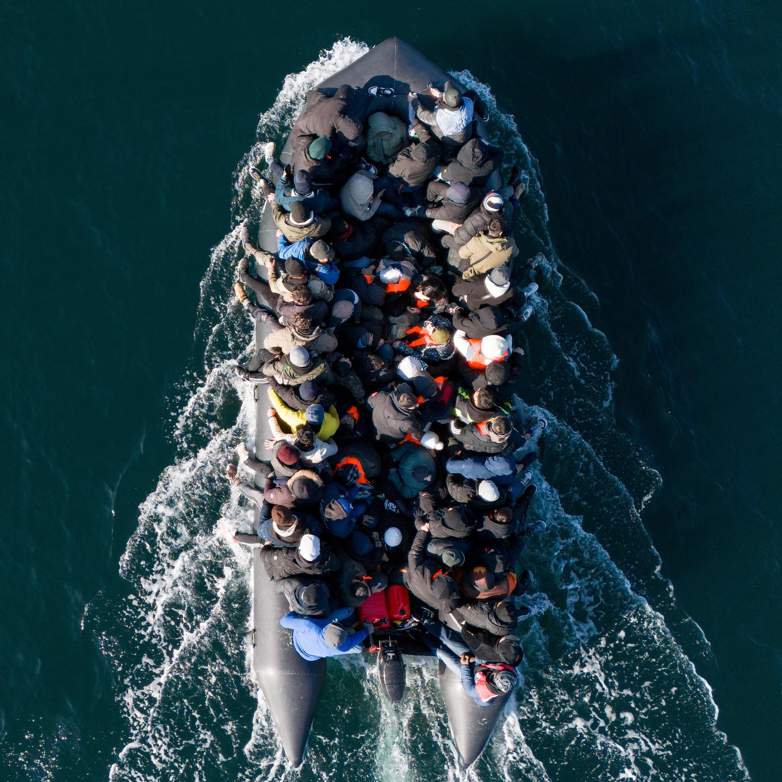 View from directly above of a small boat filled with people, surrounded by deep blue water