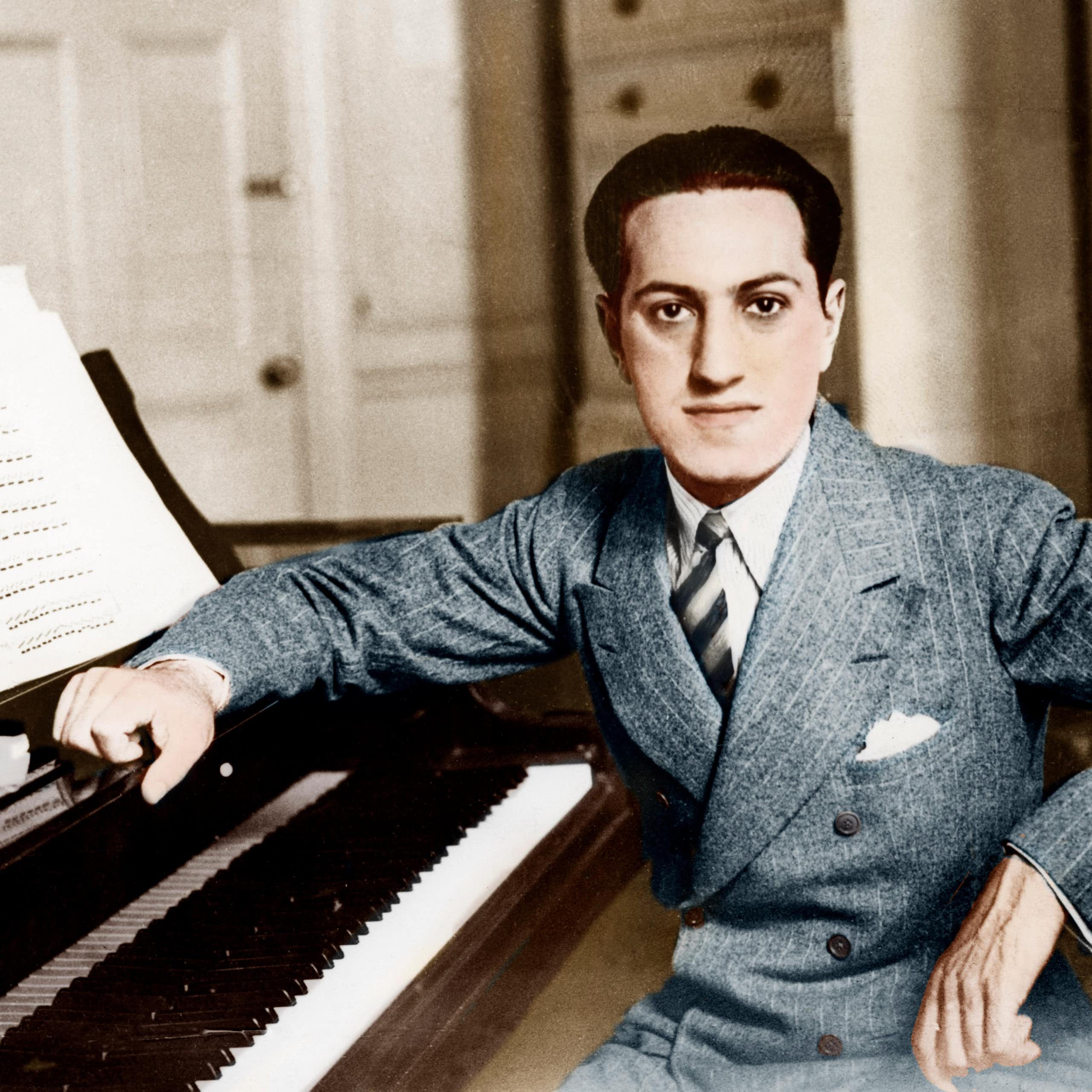 A young 1920s man (George Gershwin) sitting at a piano.
