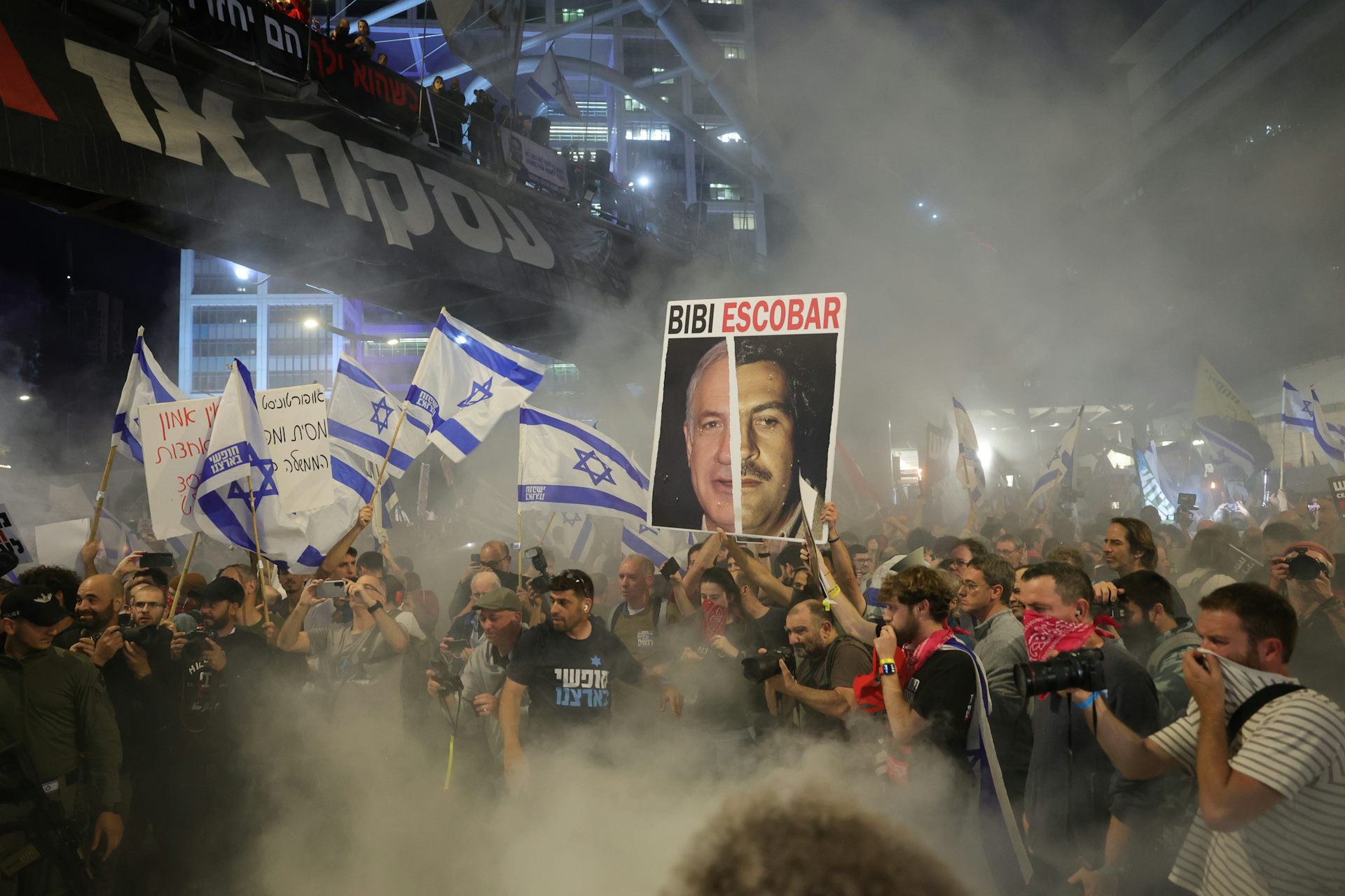 A group of people protesting holding Israeli flags.