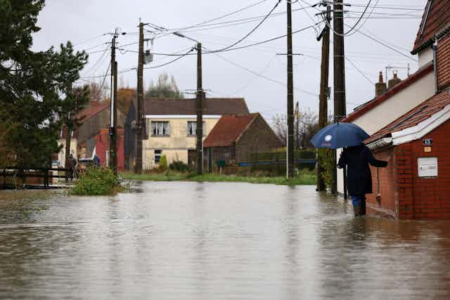 Une femme dans une rue inondée en novembre 2024, près de Saint-Omer