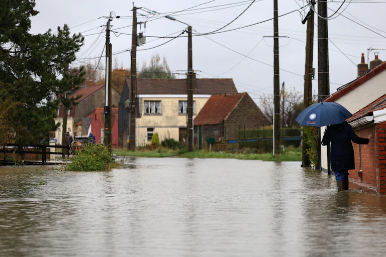 Une femme dans une rue inondée en novembre 2024, près de Saint-Omer