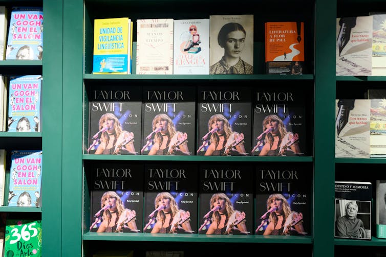 Rows of books on display on green shelves, displayed cover-side out.