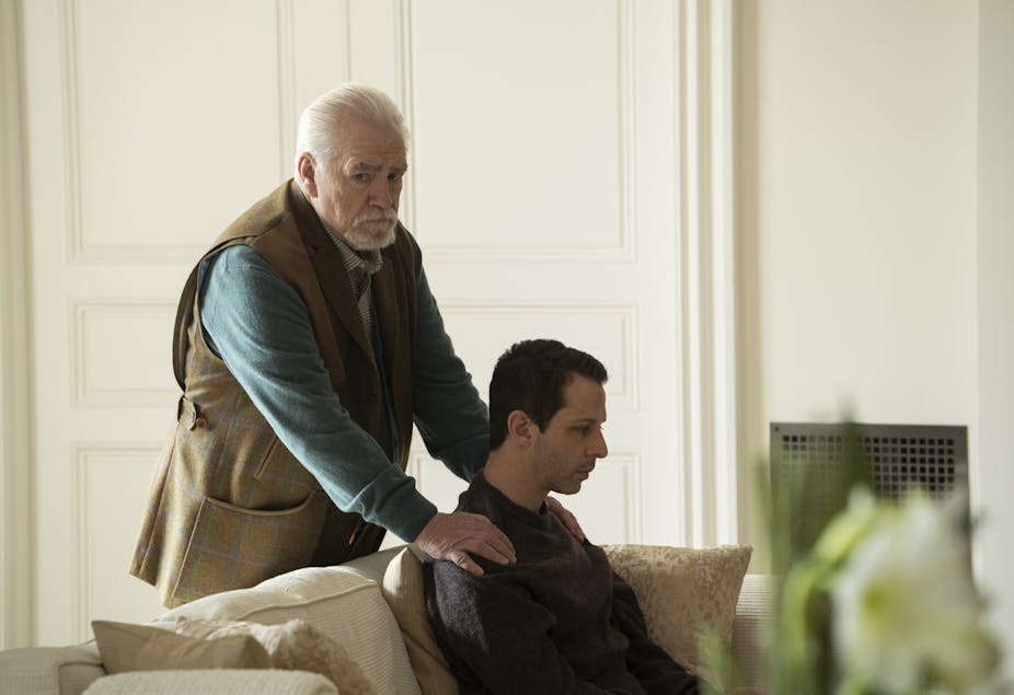 In a still from the HBO Series "Succession," patriarch Logan Roy, played by Brian Cox, is seen rubbing the shoulders of his son and heir apparent. Despite the seemingly affectionate gesture, the elder Roy looks off into the distance with a look of concern.