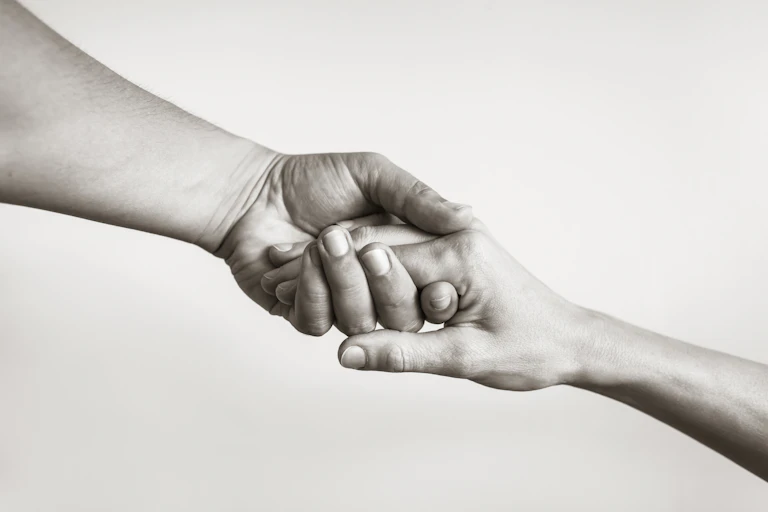 Black and white photo of two hands clasping