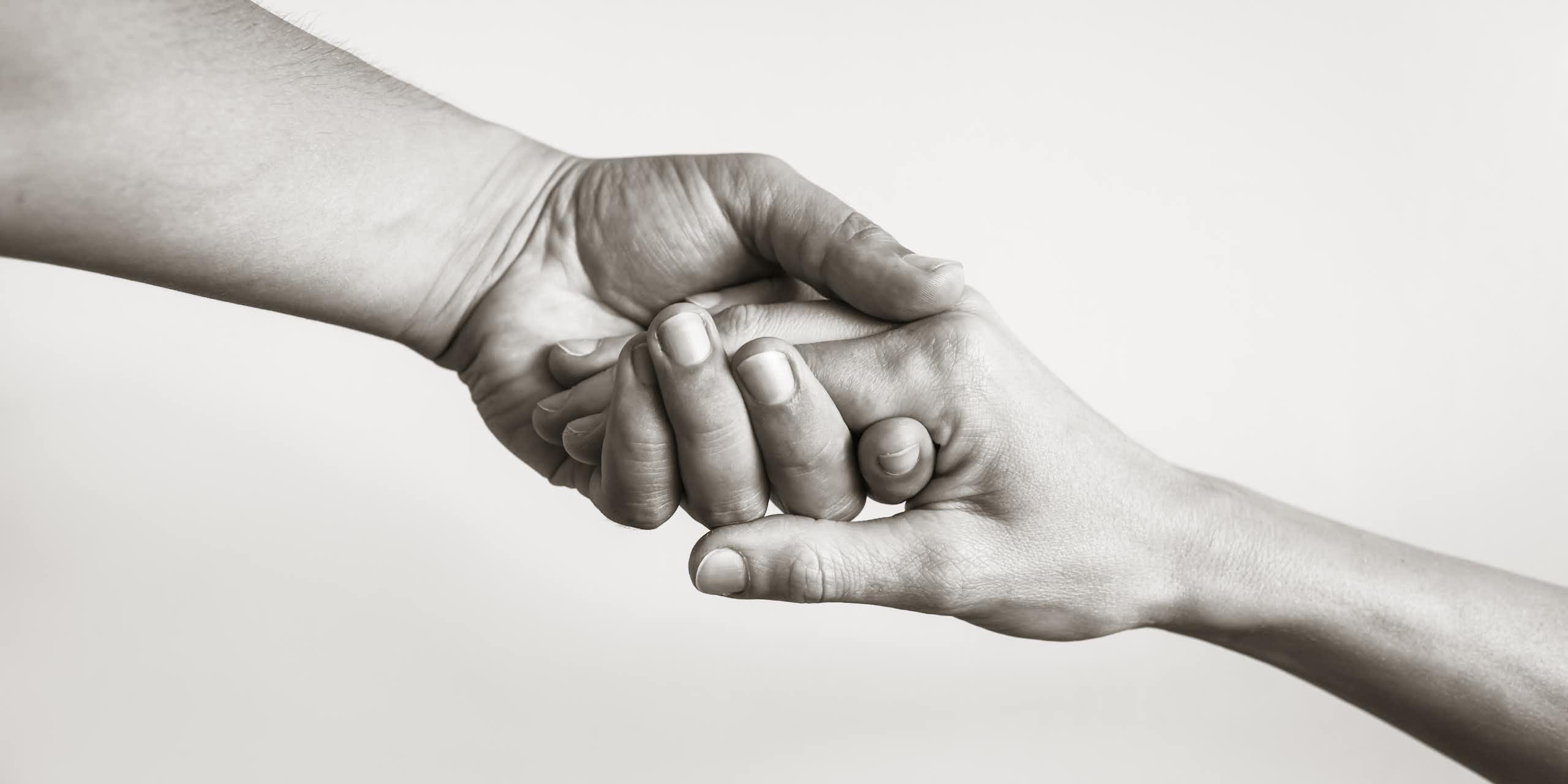 Black and white photo of two hands clasping
