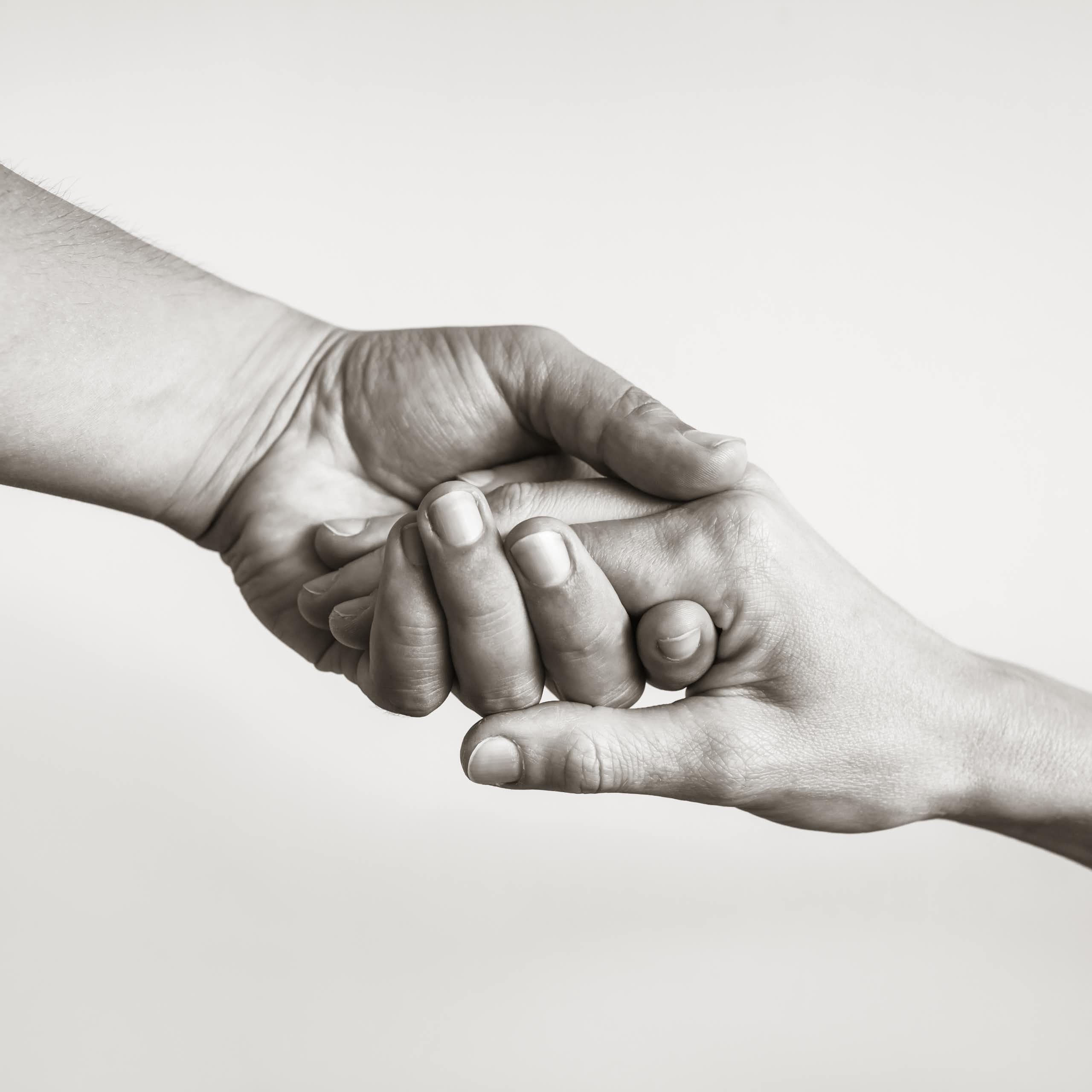 Black and white photo of two hands clasping