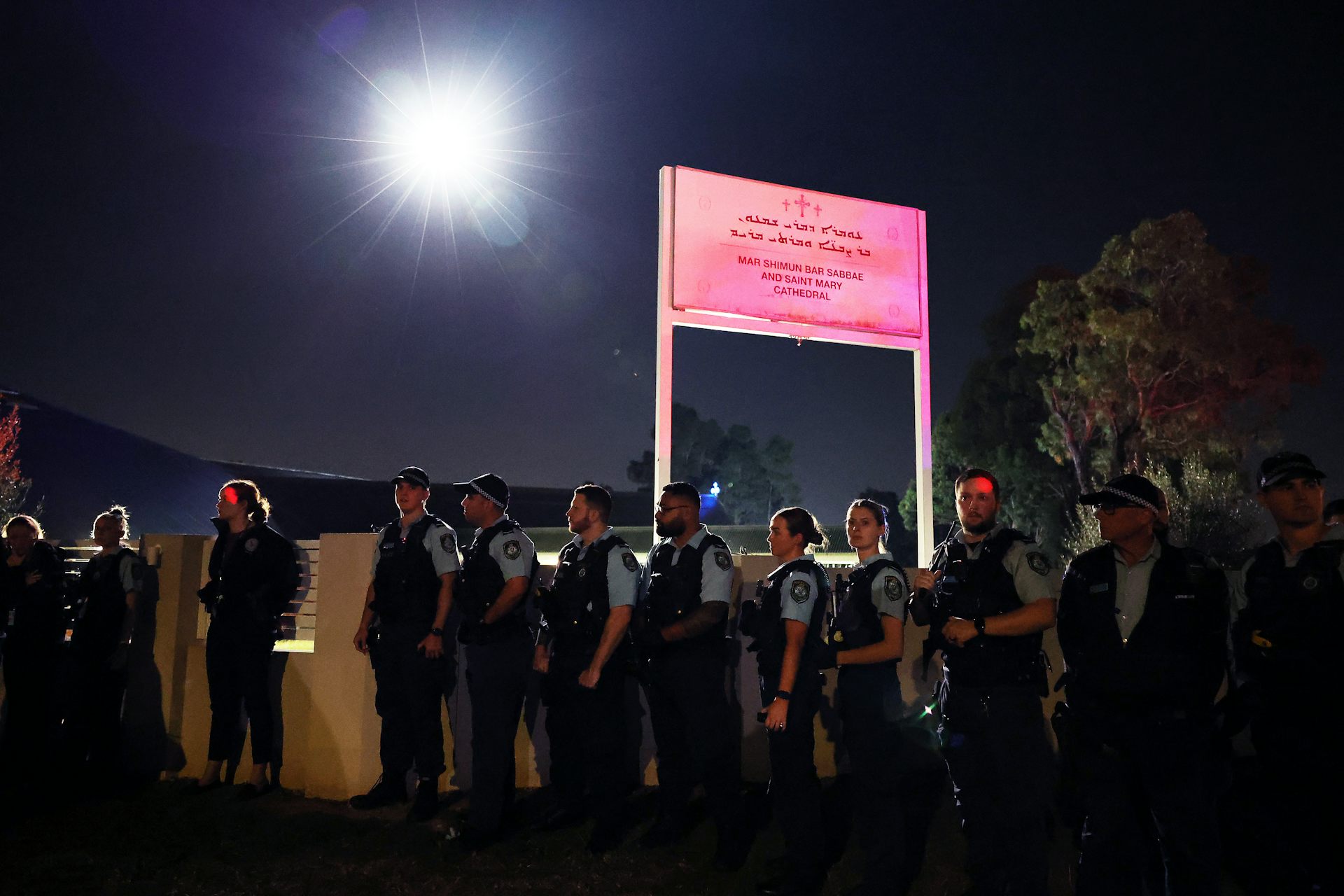 Police stand outside a church fence.