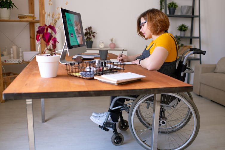 Woman in wheelchair works at desk