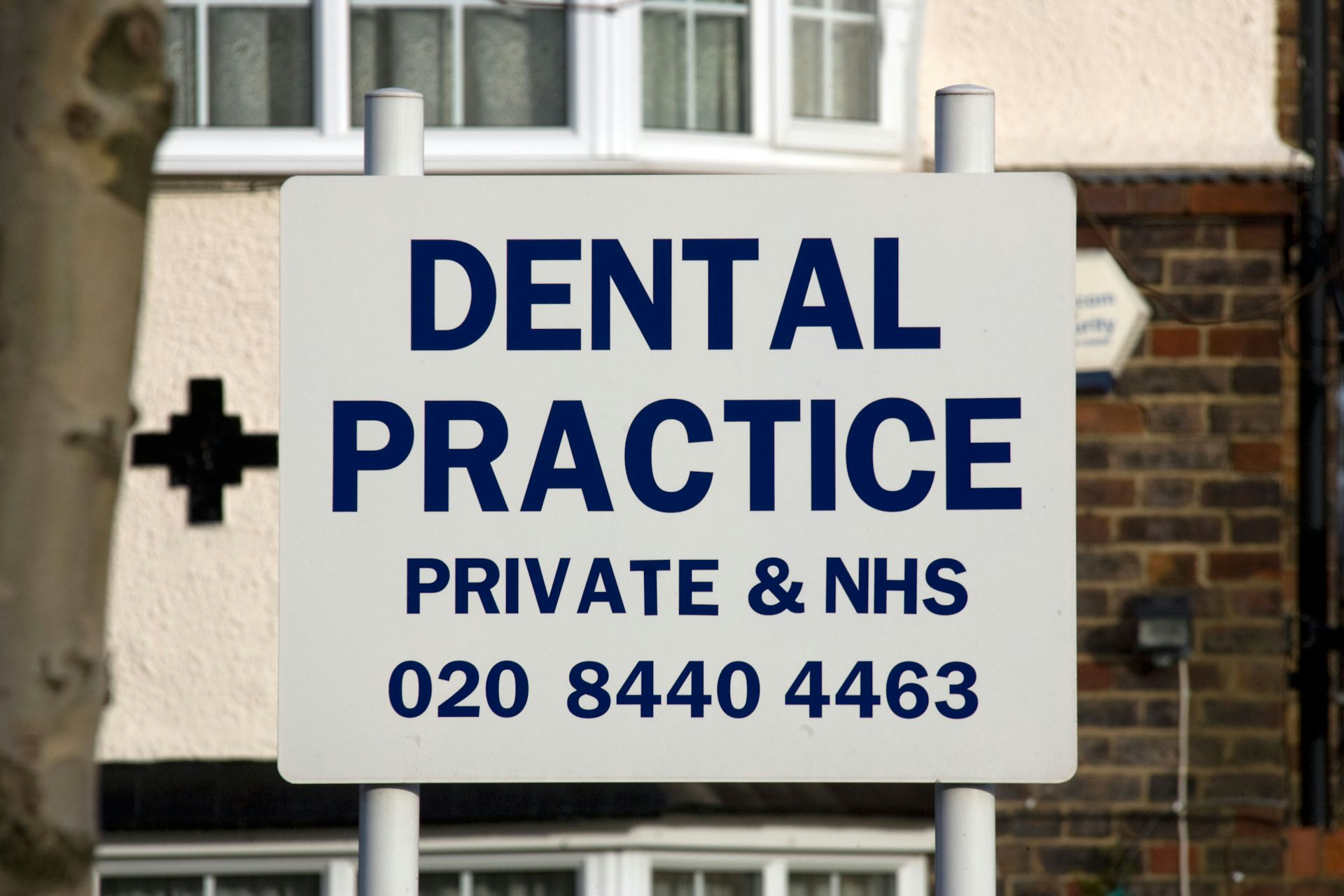 A dental practice sign, advertising both private and NHS services.