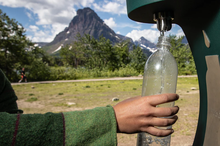 A hand seen at a water bottle filling station.