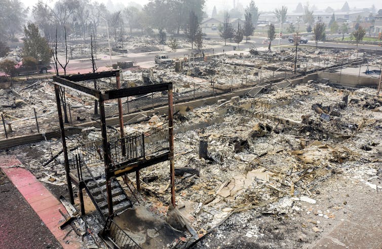 A burned-out residential landscape with a freestanding staircase.