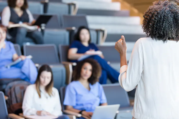 Health care provider lecturing to an audience of medical students