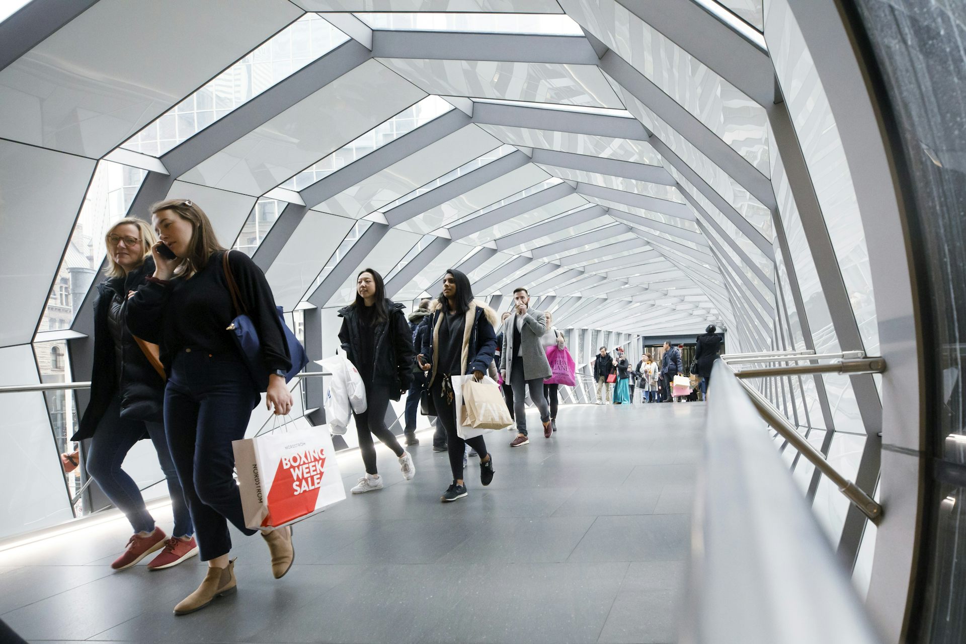 Des personnes marchent sur un passage piéton aérien