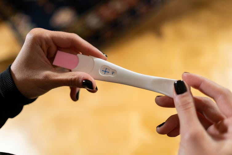 Person holds pregnancy test