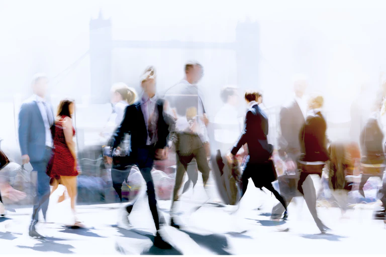 Wide panoramic view of people crossing the road, slightly blurred.