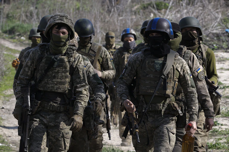 Ukrainian soldiers march in formation wearing full battledress.