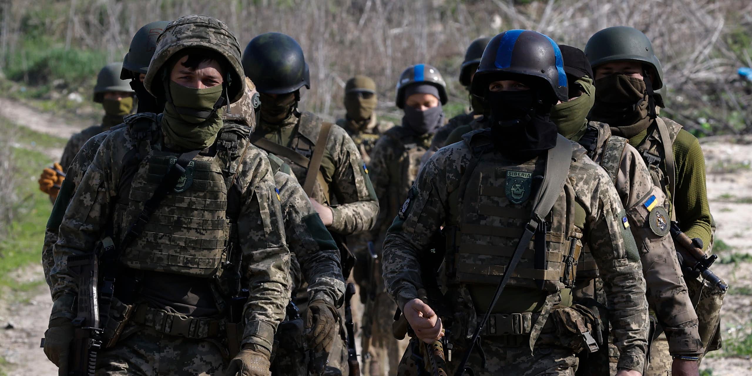 Ukrainian soldiers march in formation wearing full battledress.