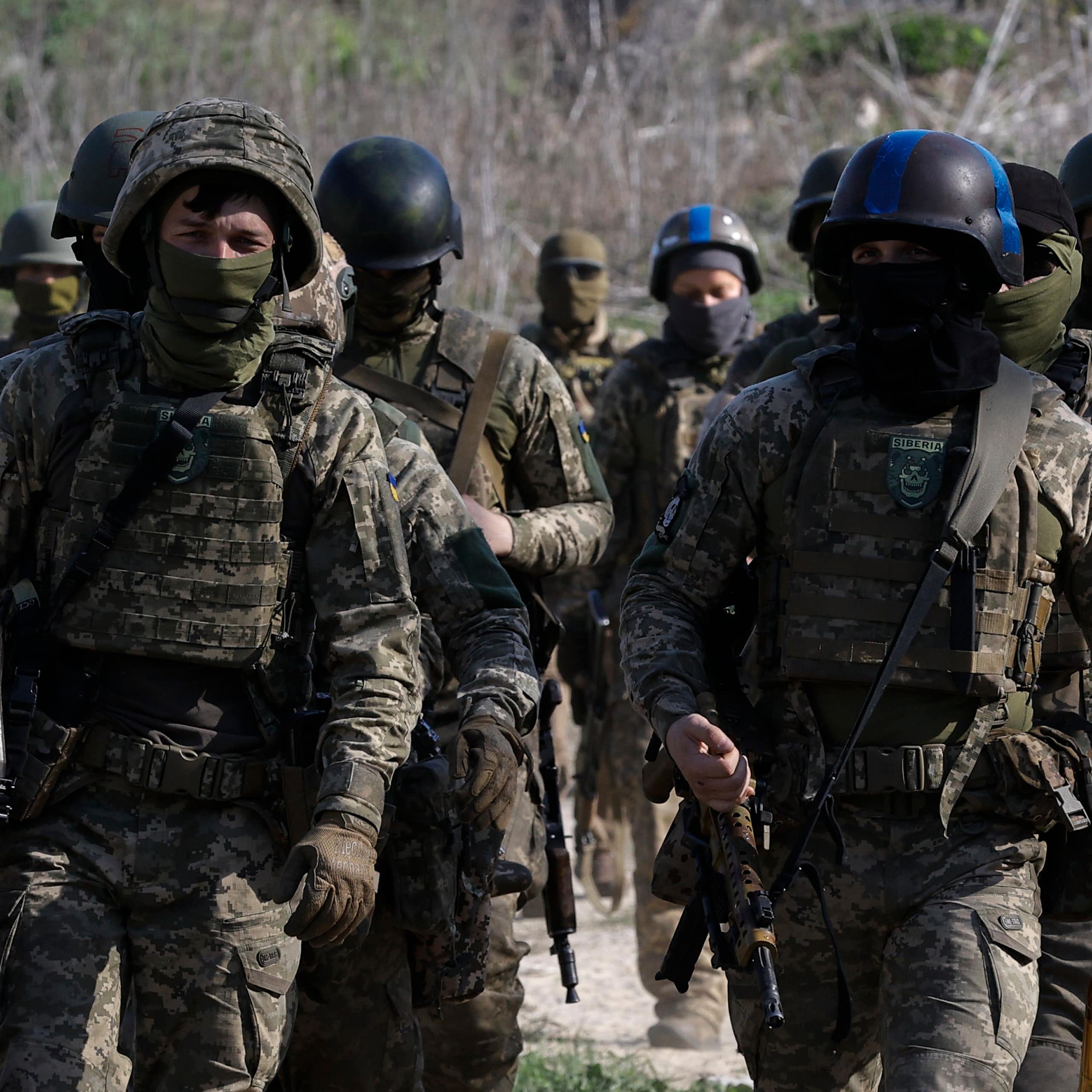 Ukrainian soldiers march in formation wearing full battledress.