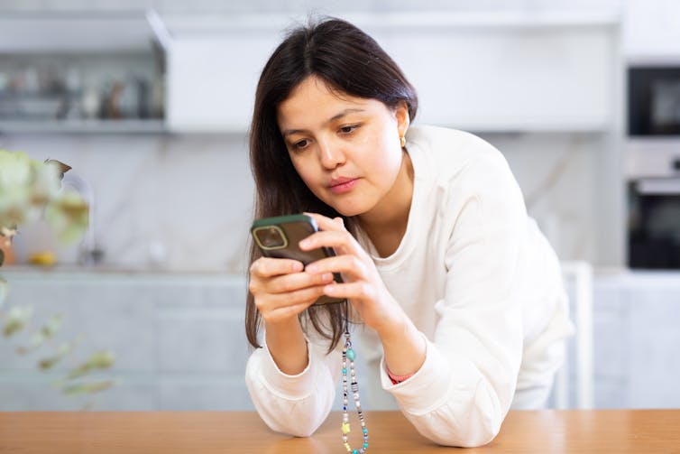 A woman looks at her phone.