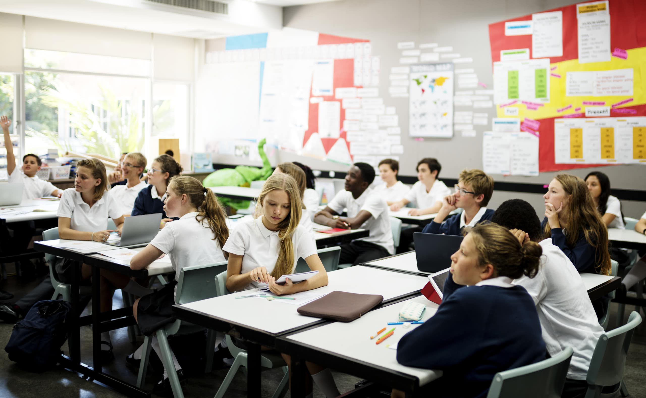 School students wearing uniform sitting in classroom