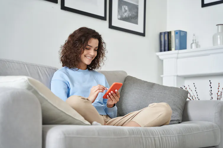 Teenage girl smiling at phone