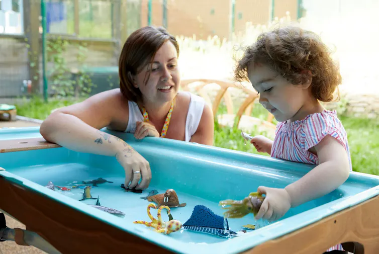 Woman and child playing outside at tray table