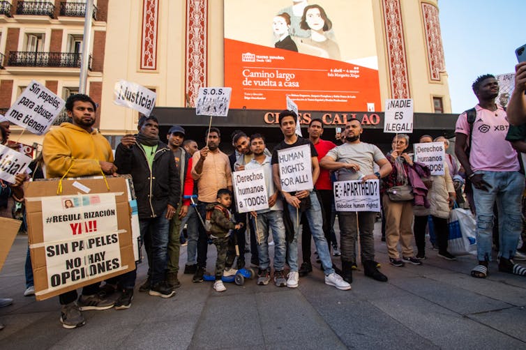 Protesters with signs gather at a rally.