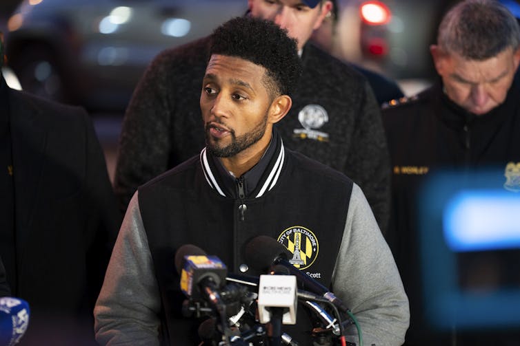 A Black man speaking at a podium.