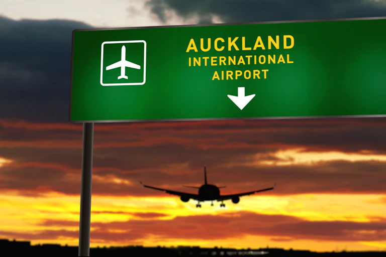 airplane landing at Auckland Airport with a sunset in the background