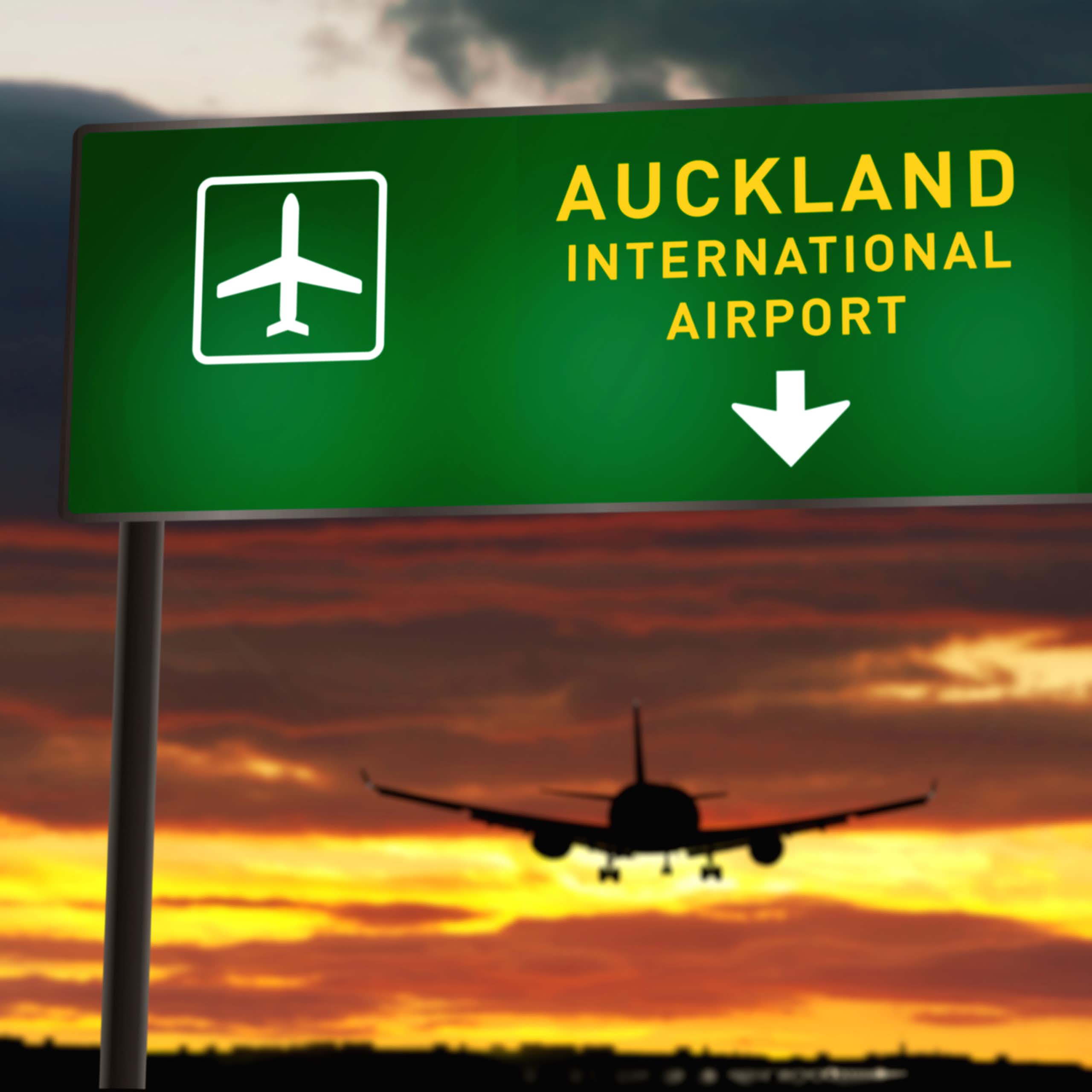 airplane landing at Auckland Airport with a sunset in the background
