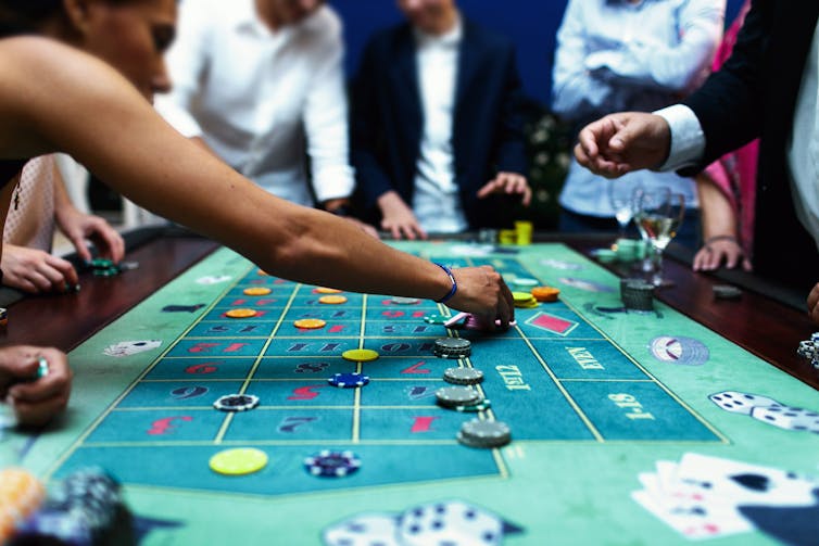 People playing a casino table game.