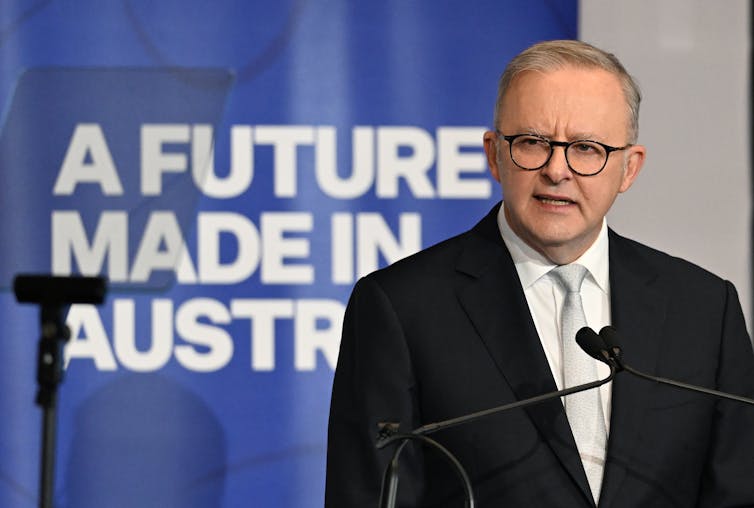 anthony albanese, man in front of sign