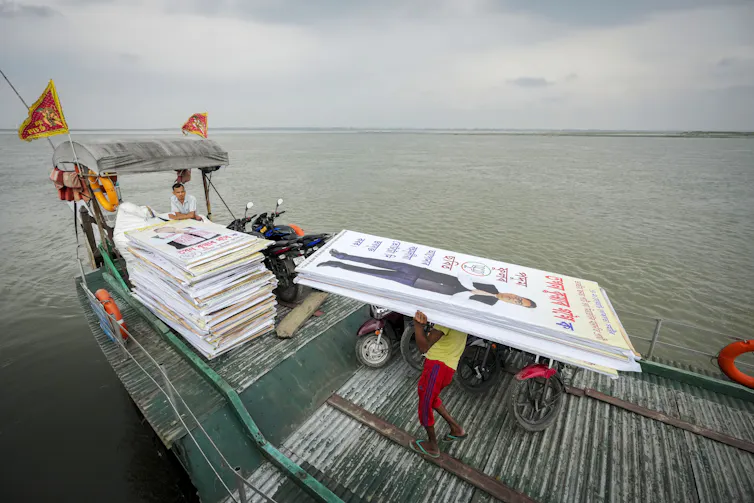 BJP election signs being ferried across a river.