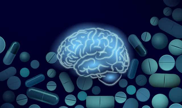 Blue illustration of brain on background of pills and capsules