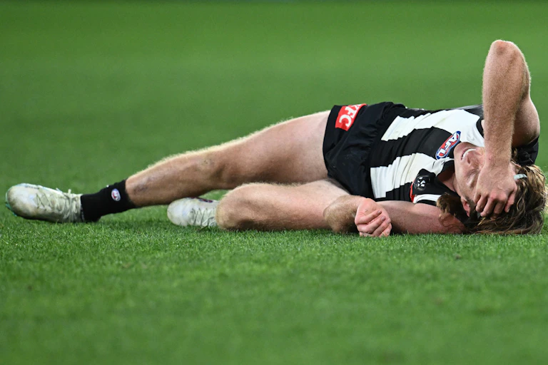 Collingwood player Nathan Murphy lays injured during a game