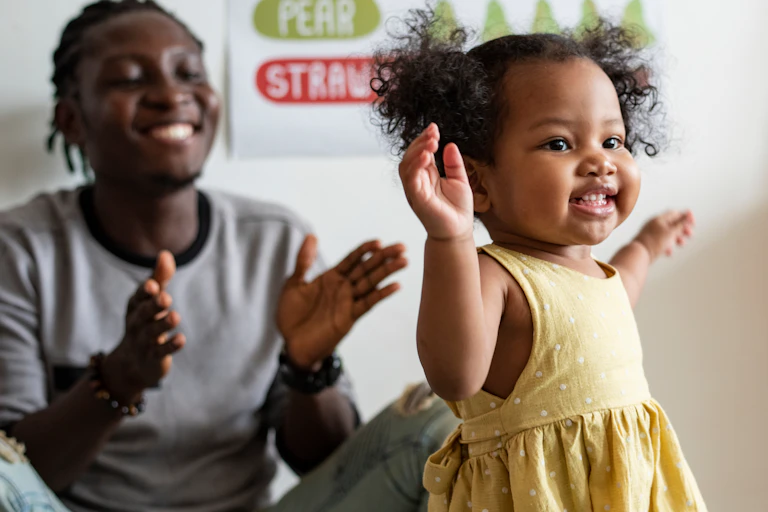 Happy toddler and adult in nursery