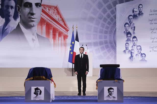 Le président  Emmanuel Macron se tient devant le cercueil  des résistants arméniens Missak et Mélinée Manouchian à Paris, le 21 février 2024. Leurs dépouilles ont été transférées au Panthéon, mausolée des héros nationaux, après un hommage national.