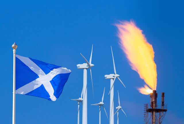 A Scottish flag next to wind turbines and a gas flare.
